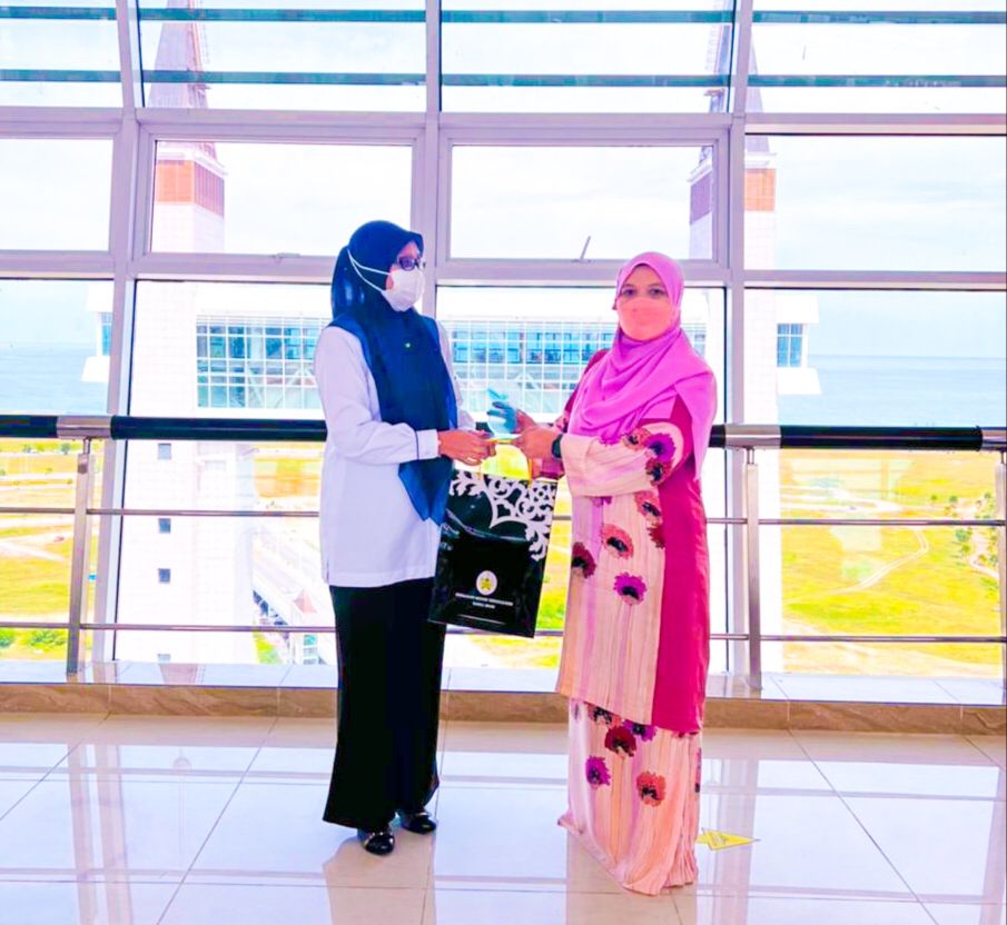 Pengarah Badan Kawal Selia Air Melaka, Puan Faizah (kiri) saling bertukar cenderahati dengan Pengarah Lembaga Sumber Air Terengganu, Puan Safura (kanan). 